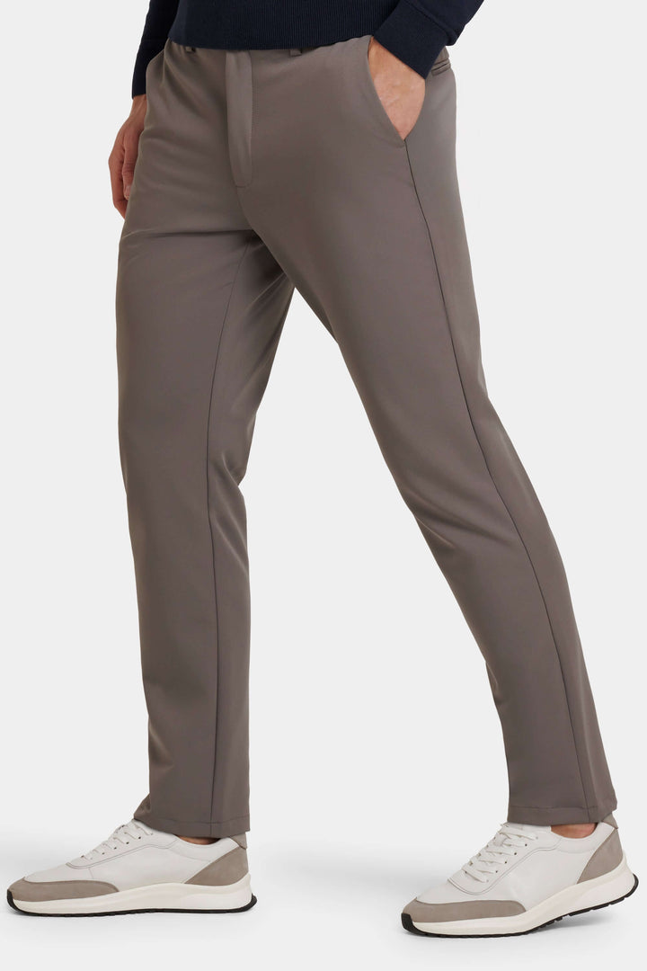 Mann trägt graue Tech-Pantalons, im Stehen, betont den modernen Schnitt und hervorragenden Komfort.
