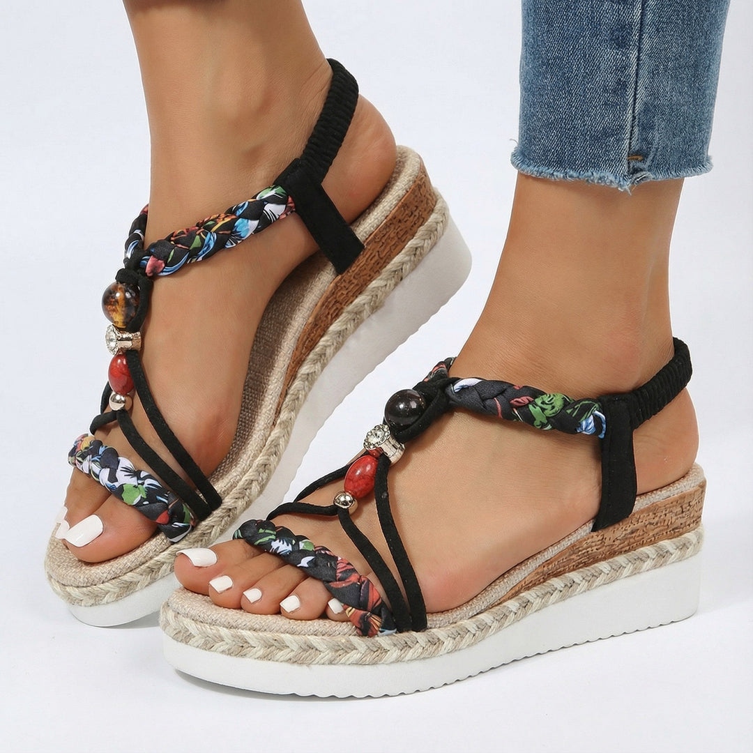 Modische Damen Sandalen mit zarten Perlen, geflochtenem Riemen & leichter Plateausohle. Für warme Sommertage.