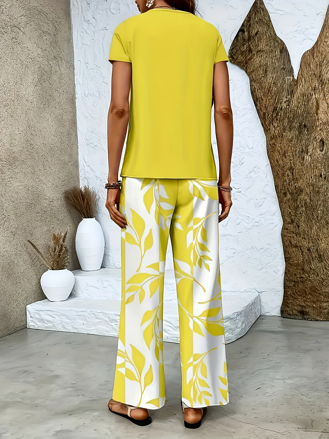 Dame in elegantem Sommer Zweiteiler: Weite Hose & Kurzarmshirt, komfortabel für Spaziergänge.