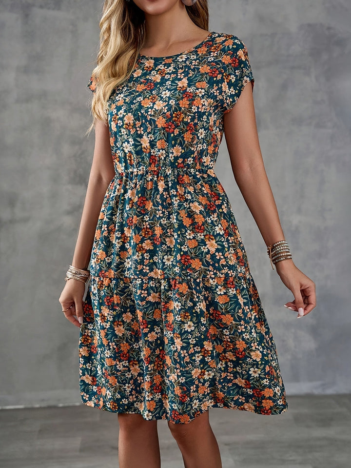 Stilvolles Damen Urlaubskleid, knielang, mit bunten Blumen und Kurzarm. Ideal für warme Sommertage.