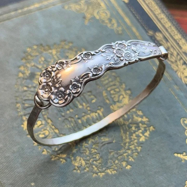Silberfarbenes Vintage Damen Armband mit filigraner Blumen-Gravur, perfekt für elegante Anlässe.