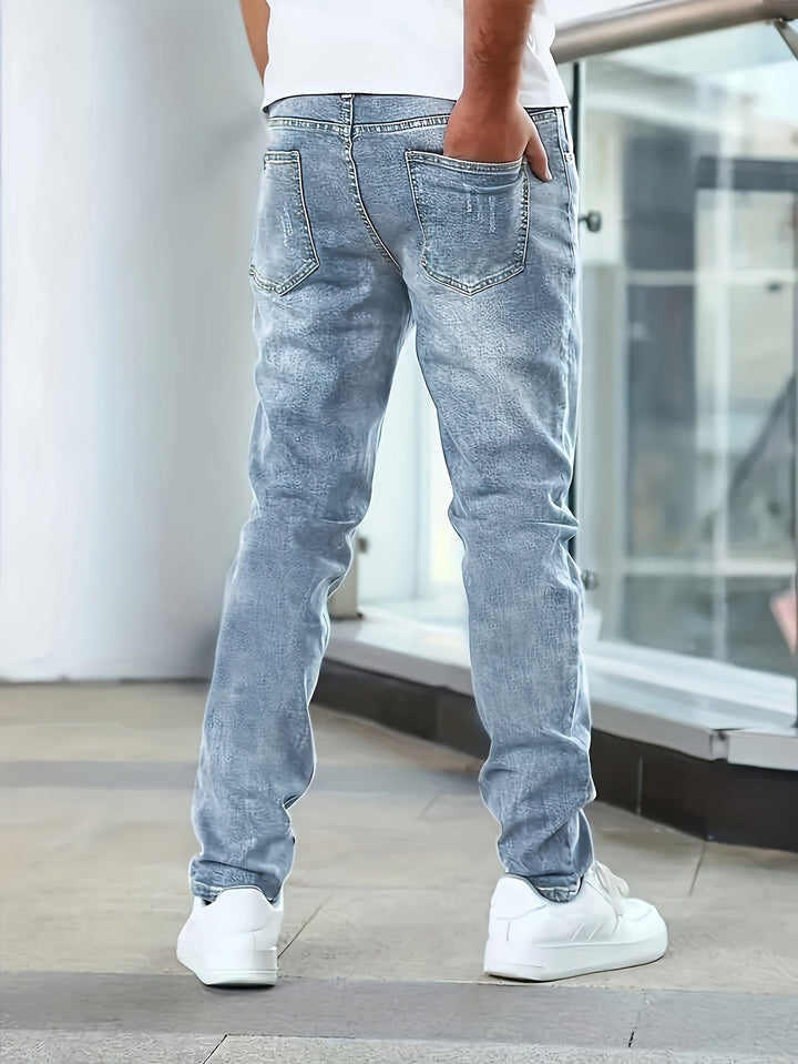 Stehender Mann in blauen Herren Stretch-Jeans, präsentiert flexible Passform und modischen Alltagslook.
