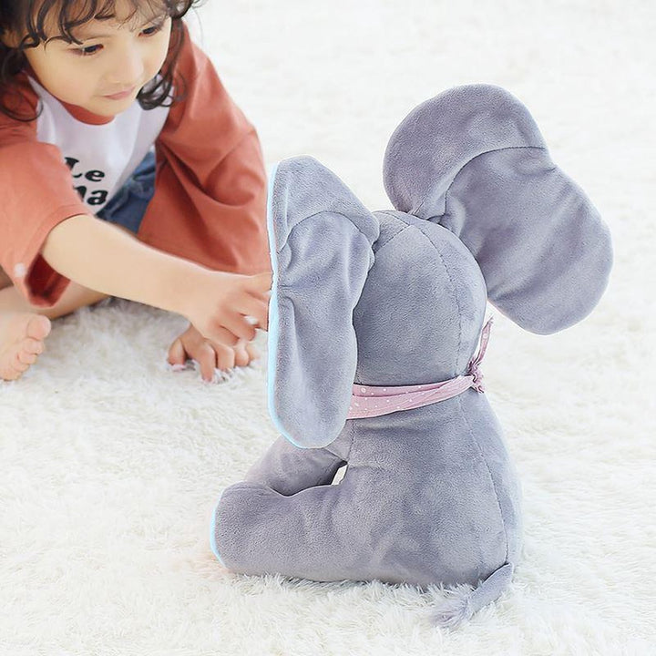 Kind spielt lachend mit interaktivem Plüschelefant Ellie, singendem & wackelndem Kuscheltier.