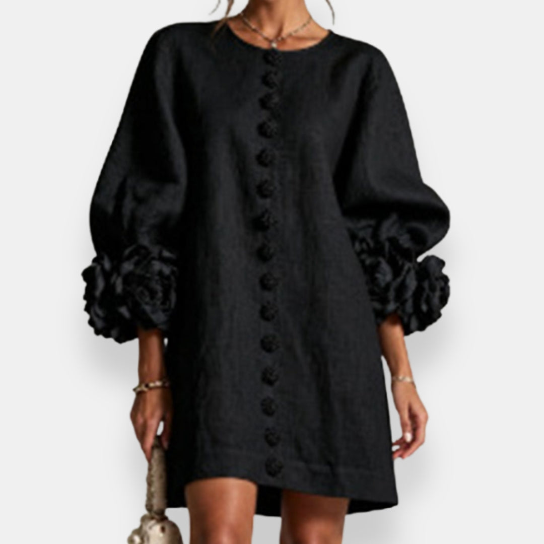 Rückenansicht eines eleganten Damen Maxikleides mit zartem Blütenrelief und Ballonärmeln.