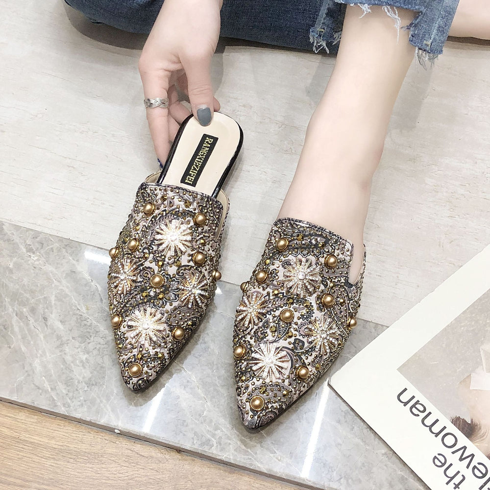 Bequeme flache Damen-Slipper mit spitzer Zehenpartie und stilvollen Metall-Details im römischen Design.