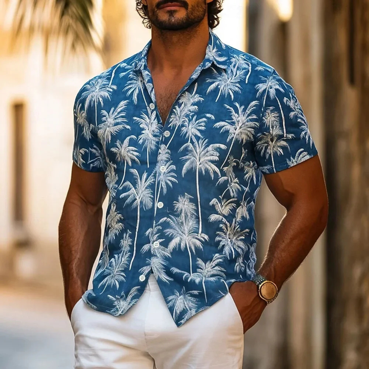 Mann trägt modernes Kurzarmhemd mit Palmenprint. Stylisches Sommerhemd, perfekt für entspannte Urlaubstage.