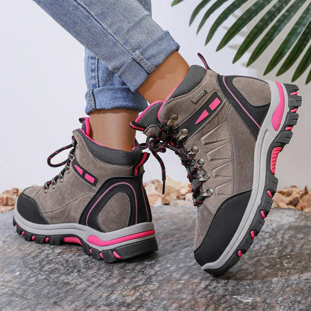 Rutschfeste rosa Wanderschuhe für Damen, die auf feuchten und schlammigen Wegen sicheren Halt bieten.