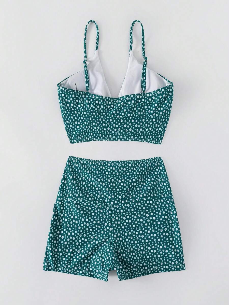 Frau trägt stylisches Damen Bikini Set "Marielle" in blau-grün mit Blumenmuster am Strand.