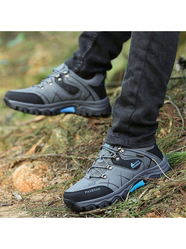 Herren Steinpfad Wanderschuh in Grau auf einem Waldweg. Bequem & robust für Outdoor-Erlebnisse.