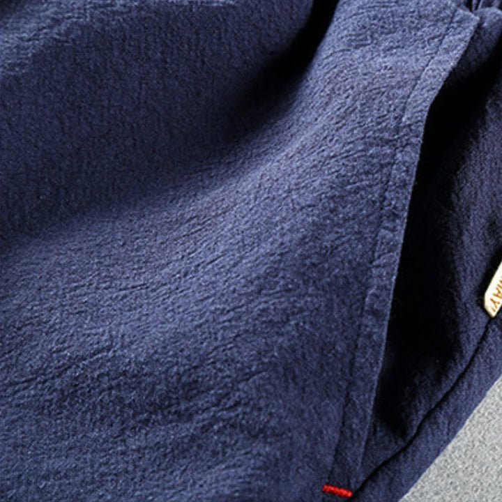 Junger Mann trägt dunkelblaue, moderne Herren Jogger mit schmal zulaufendem Bein für Freizeit und Alltag.