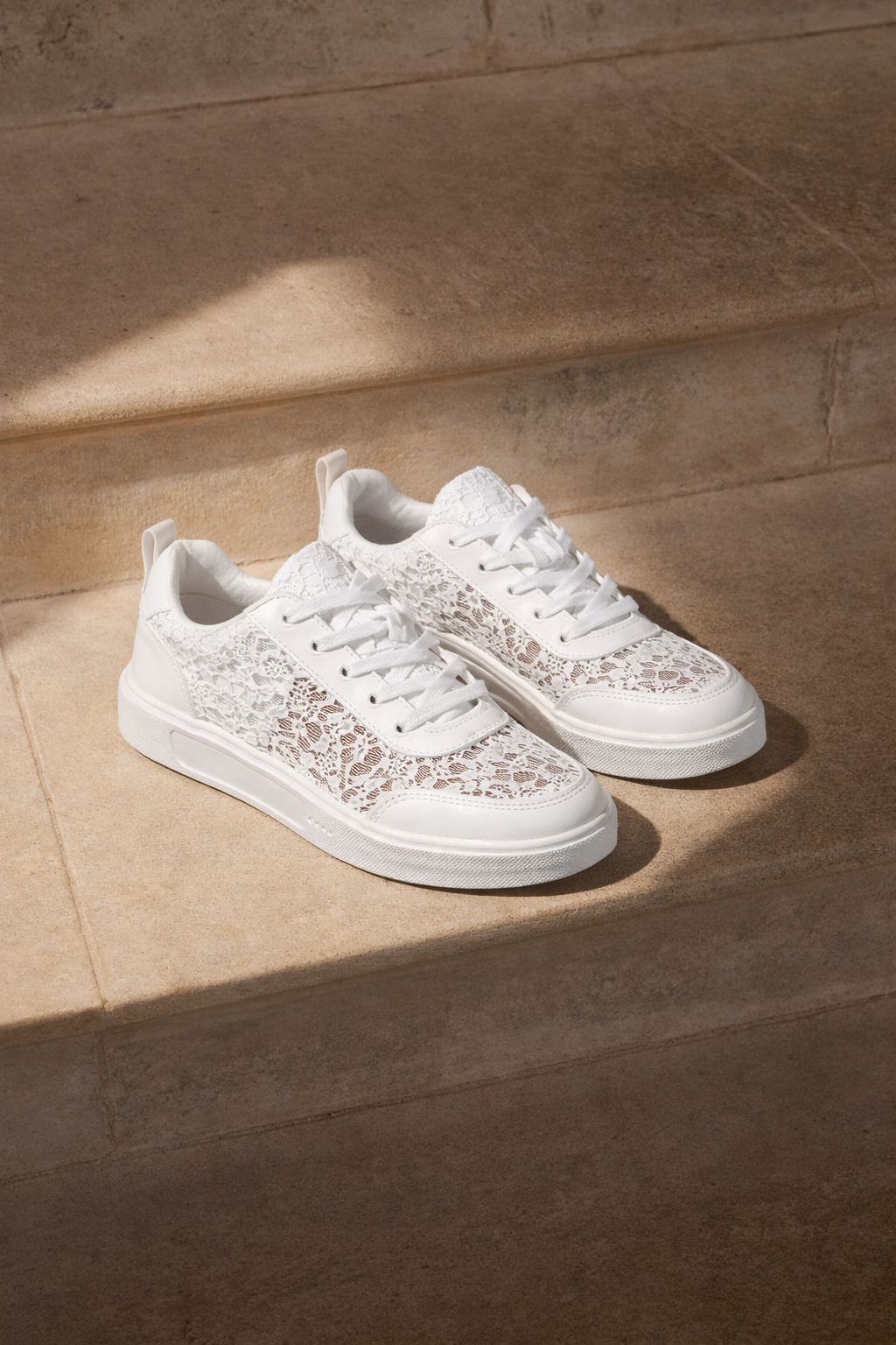 Stylische weiße Damen Sneakers von der Seite, mit verspieltem Blumenmuster und leichter Sohle. Komfort für den Alltag.