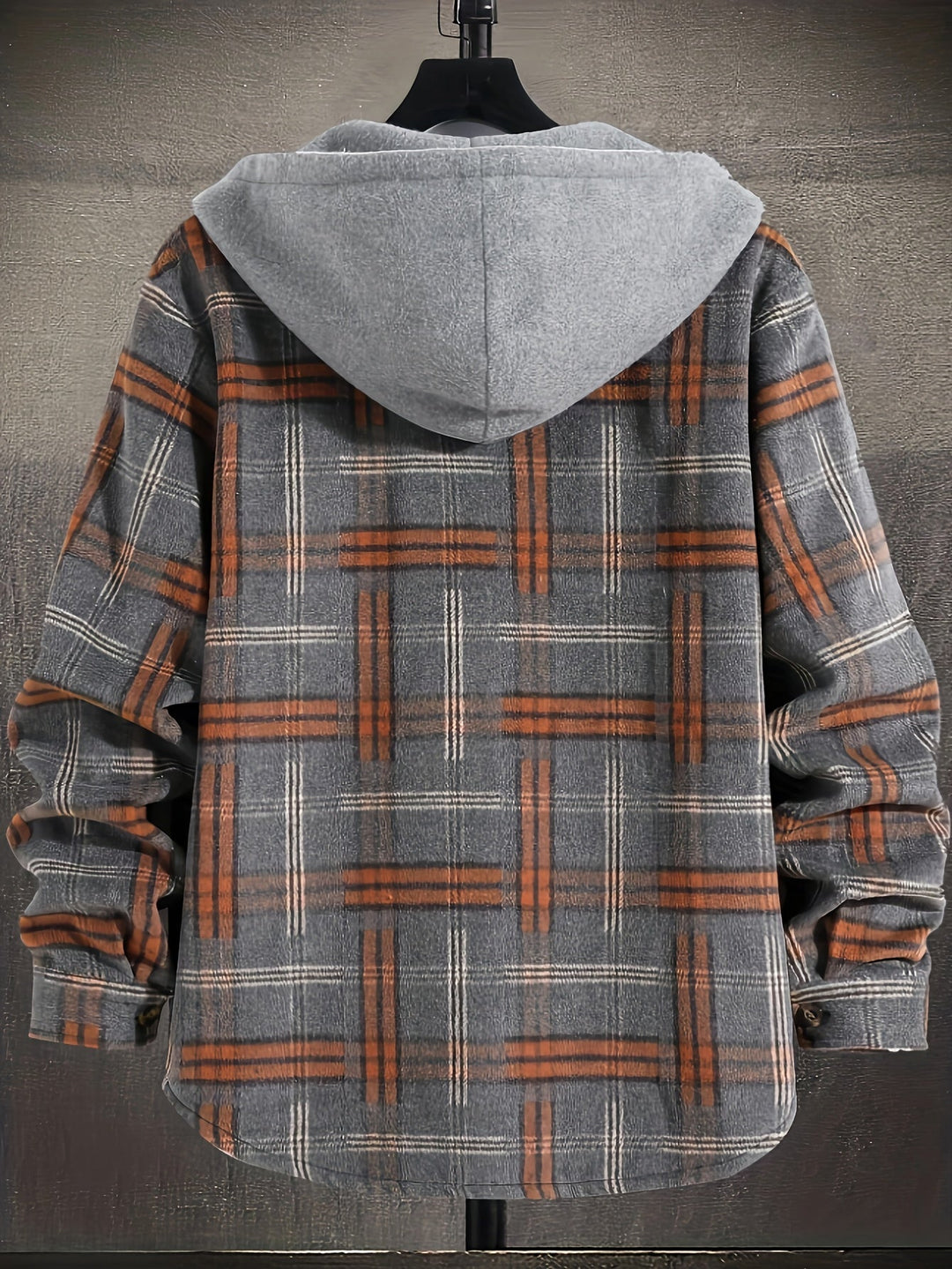 Junger Mann trägt karierte Herren Hemdjacke mit Kapuze. Lässige Outdoor-Jacke für den Herbstspaziergang.
