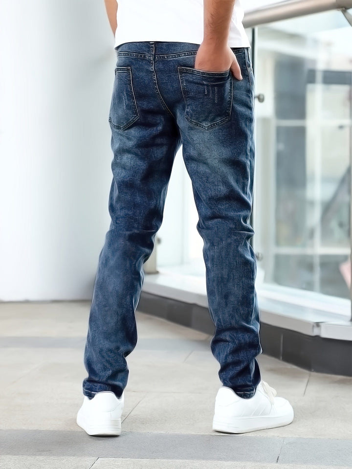 Sitzender Mann in schwarzen Herren Stretch-Jeans, demonstriert Flexibilität und Komfort der Hose.