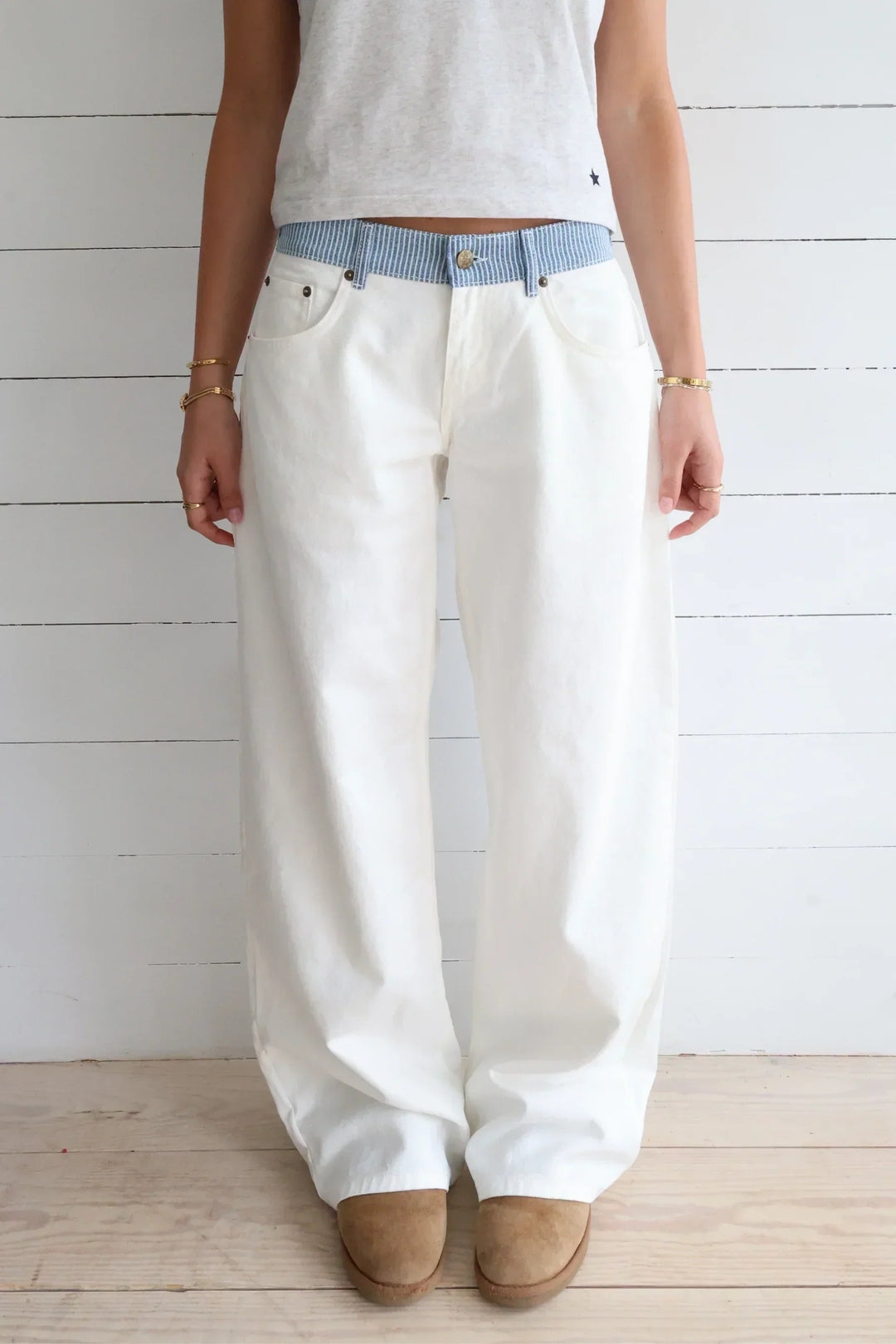 Weiße Damen Jeans mit lockerem Schnitt und gestreiftem Bund. Bequeme Streetwear Hose für lässige Freizeit-Looks.
