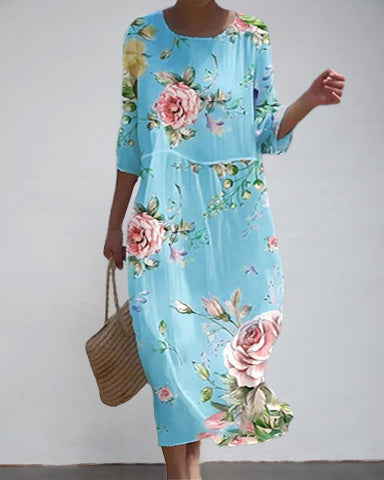 Lachende Frau trägt ein leichtes Damen Sommerkleid mit farbenfrohem Blumendruck. Bequemes Freizeitkleid für warme Tage.