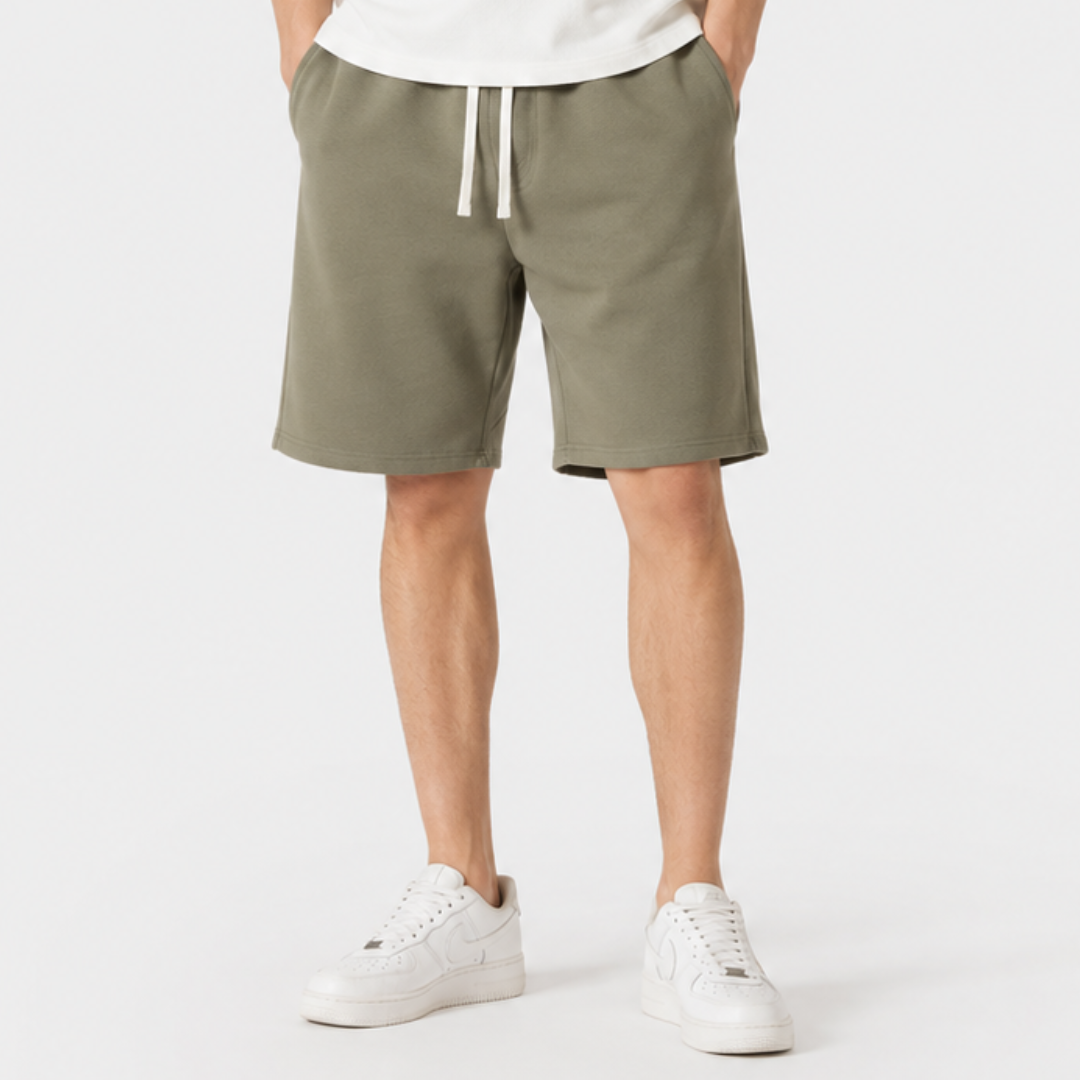 Mann trägt lockere Herren Shorts beim Entspannen. Bequeme kurze Hose für Freizeit & Alltag. Athleisure-Look.