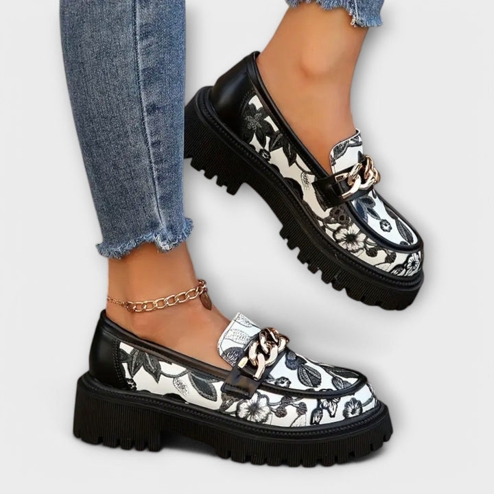 Bequeme florale Damen Slipper in Schwarz mit dicker Sohle für Freizeit & Sommer. Stylische Mokassins mit Metallschnalle.