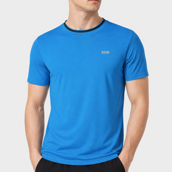 Mann in blauem, feuchtigkeitsableitendem Herren Sport T-Shirt beim Laufen im Freien.