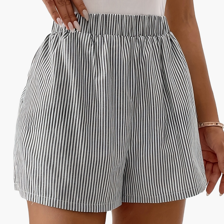 Model trägt elegante gestreifte Damen Shorts. Bequeme Freizeit-Shorts für dynamische Sommer-Outfits.