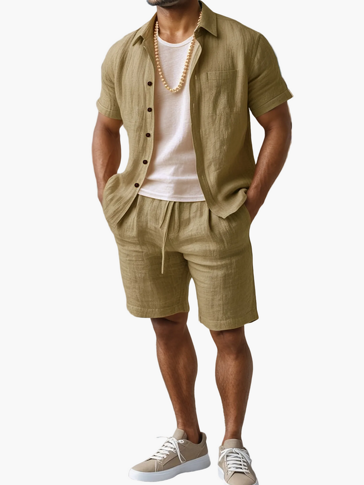 Mann trägt lässiges Leinen-Look Strand Outfit Set: Kurzarmhemd & Shorts. Perfekt für den Sommer.