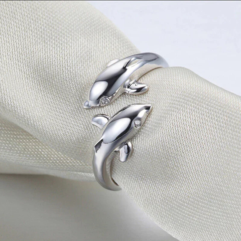 Glänzender Silberring für Damen, fein gearbeitet mit eleganten Delfinen. Ein verstellbarer Glücksbringer.