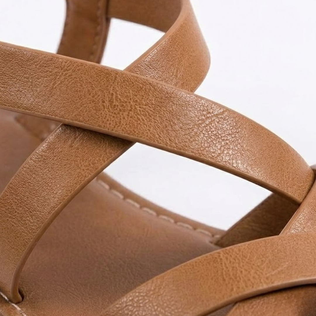 Nahaufnahme der überkreuzten Riemen bequemer, flacher Damen Sandalen – perfekte Sommerschuhe.