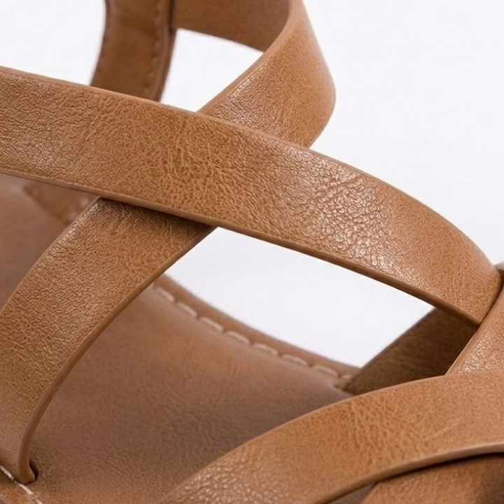 Nahaufnahme der überkreuzten Riemen bequemer, flacher Damen Sandalen – perfekte Sommerschuhe.
