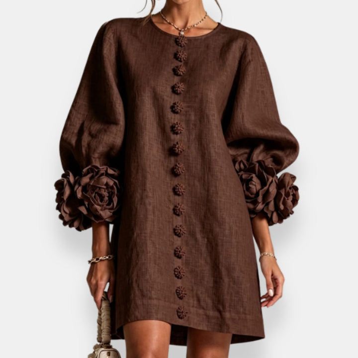 Feminin geschnittenes Damen Maxikleid mit dezentem Blütenrelief, Ballonärmeln und Knopfdetails.