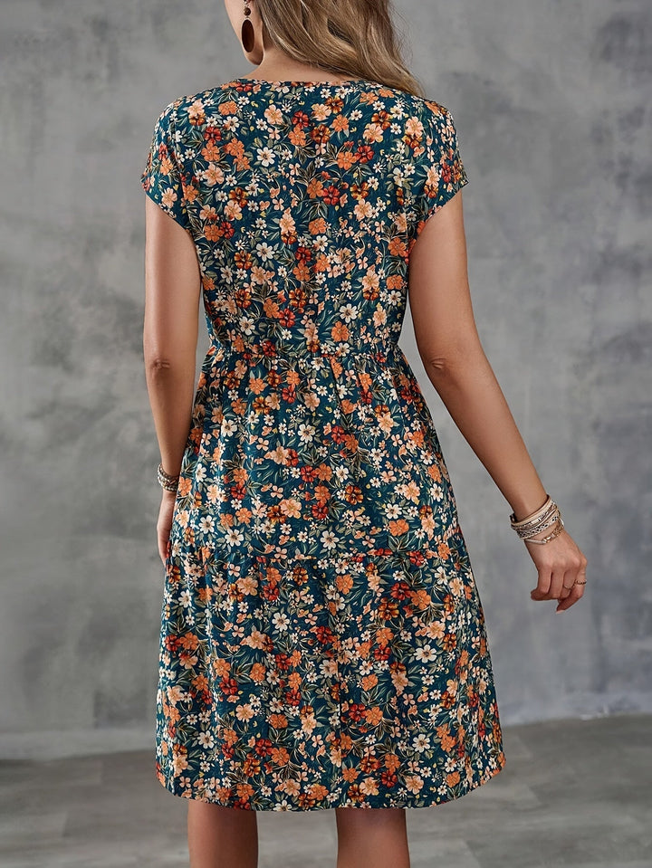 Frontansicht: Elegantes knielanges Damen-Sommerkleid mit floralem Muster und Kurzarm. Luftig und bequem.