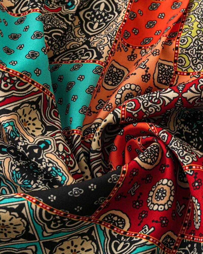 Nahaufnahme des einzigartigen Prints auf dem schwarzen Damen Kurzarmshirt mit V-Ausschnitt. Moderne Damenmode.