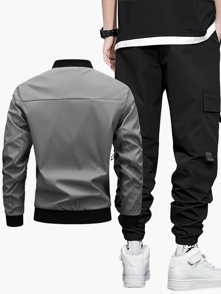 Mann trägt trendiges Herren Streetwear Set: Bomberjacke & Cargo Jogginghose. Komfortables Outfit für Freizeit & Urban.
