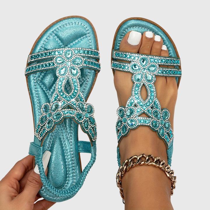 Bequeme himmelblaue Flachsandalen für Damen mit sicherem Fersenriemen.