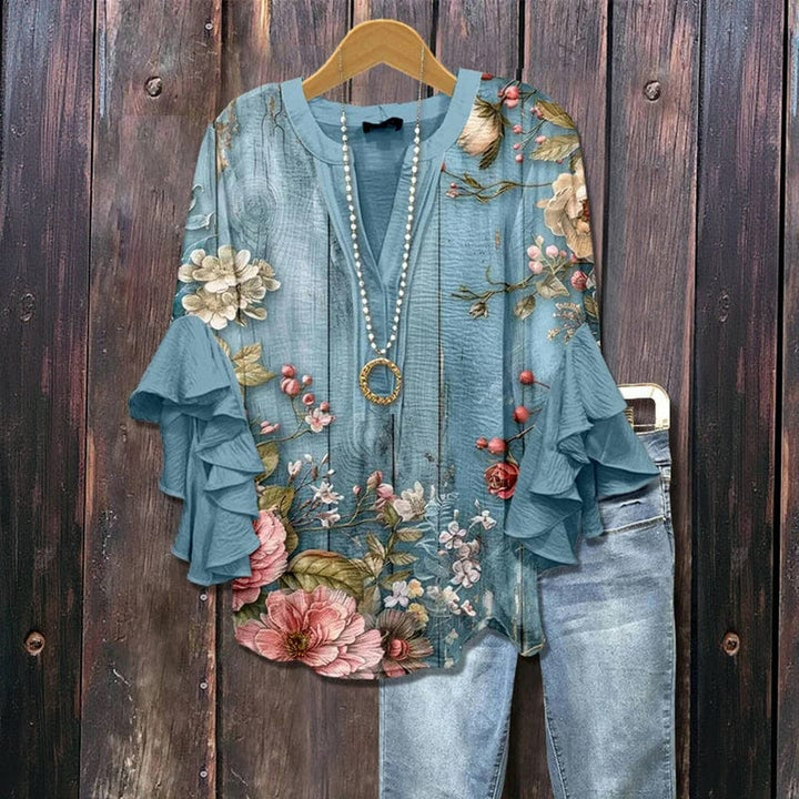 Damen Bluse mit buntem Blumenmuster, langen Rüschenärmeln und Rundhalsausschnitt. Modische Frühlingsbluse.