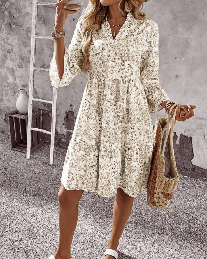 Modernes Damen Frühlingskleid in Beige, A-Linie, mit Blumenprint, Rüschenärmeln und hohem Stehkragen.