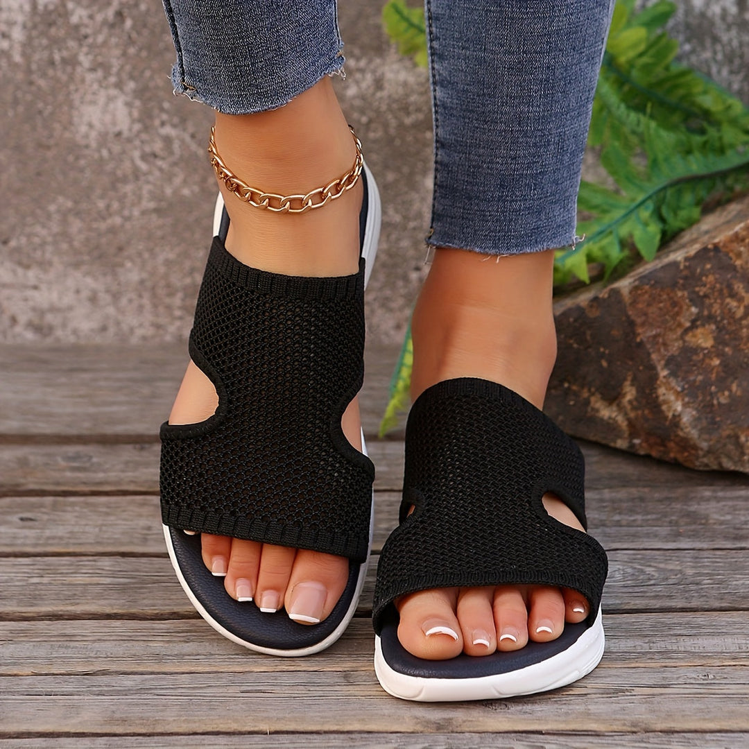 Frau trägt sportliche Slip-On Damensandalen. Bequeme Freizeitschuhe, atmungsaktiv für Sommer, Alltag, Urlaub.