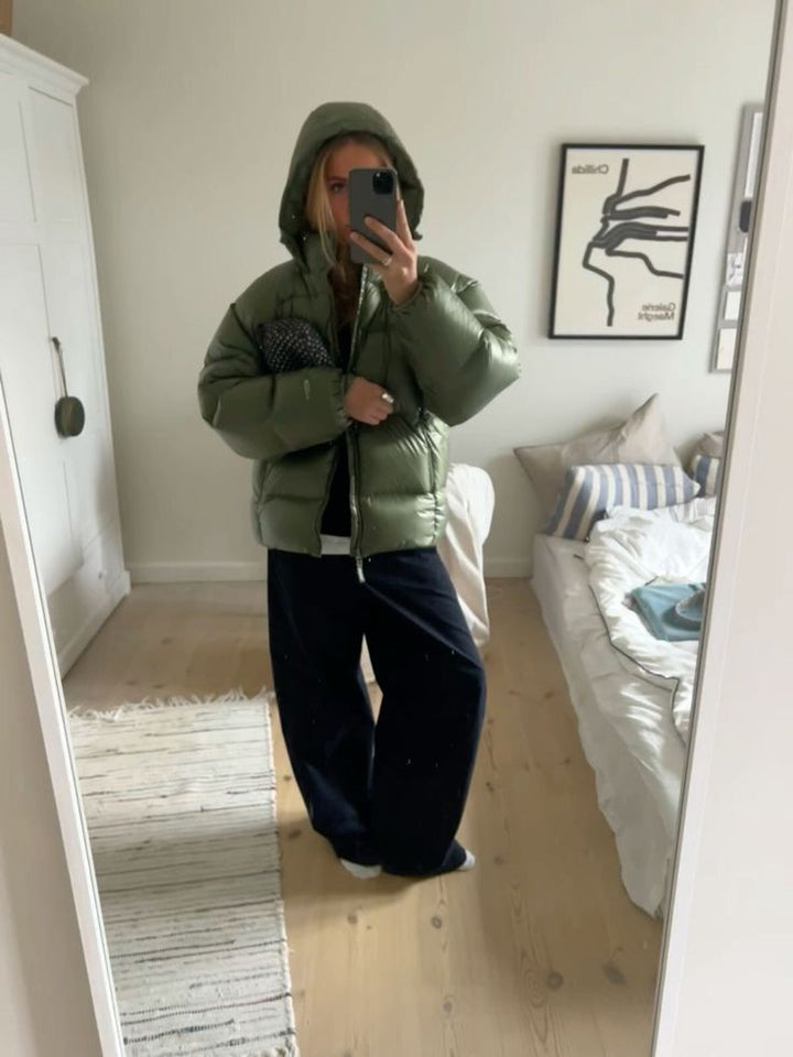 Mann trägt sportliche Outdoor-Steppjacke mit Kapuze, bietet Kälteschutz an kalten Tagen.