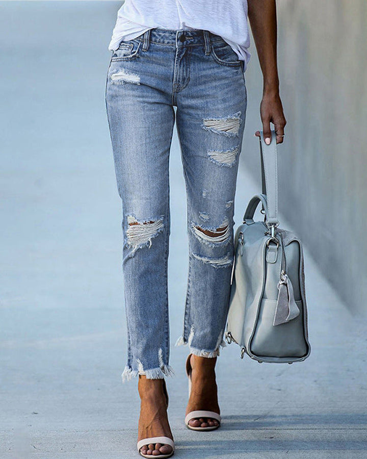 Frau trägt stylische schwarze Damen Slim Fit Jeans "Liora" mit Rissen, perfekt für den urbanen Streetstyle Look.
