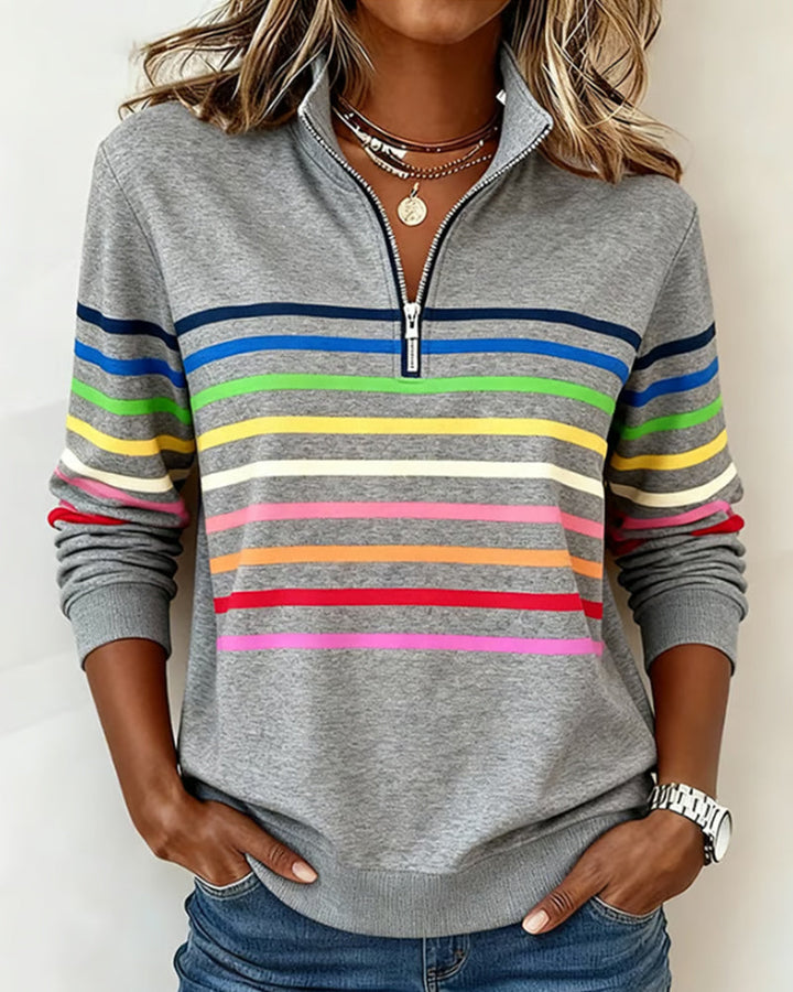 Frau trägt lockeren Damen Pastell-Pullover. Gestreifter Strick für modischen Alltagslook im Frühling.