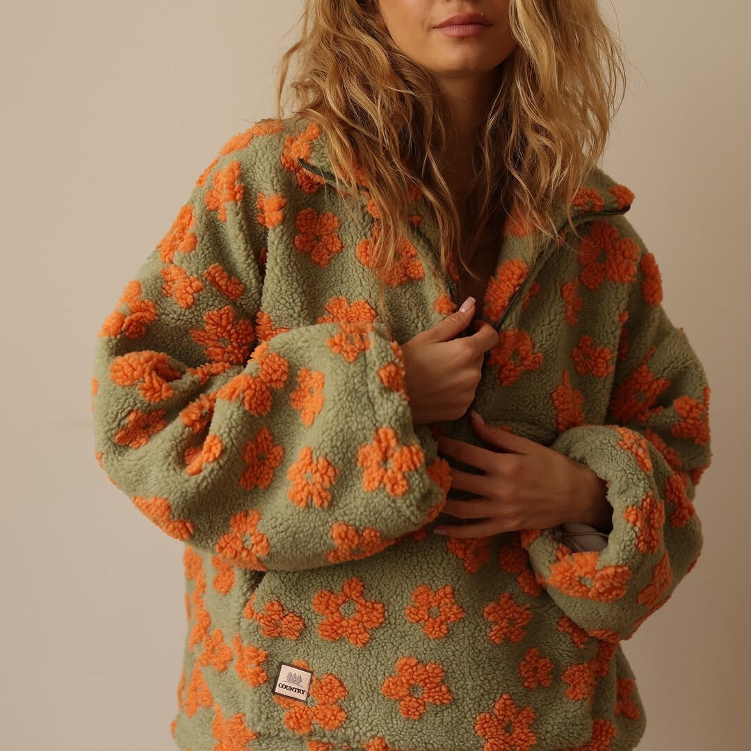 Detailansicht des weichen Materials und des Herbst-Blumenmusters auf diesem Damen Pullover.