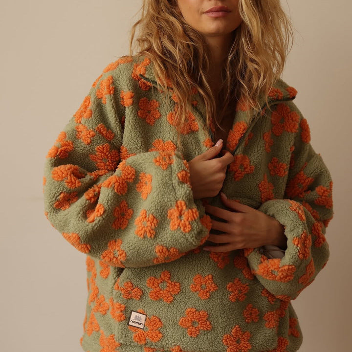 Detailansicht des weichen Materials und des Herbst-Blumenmusters auf diesem Damen Pullover.