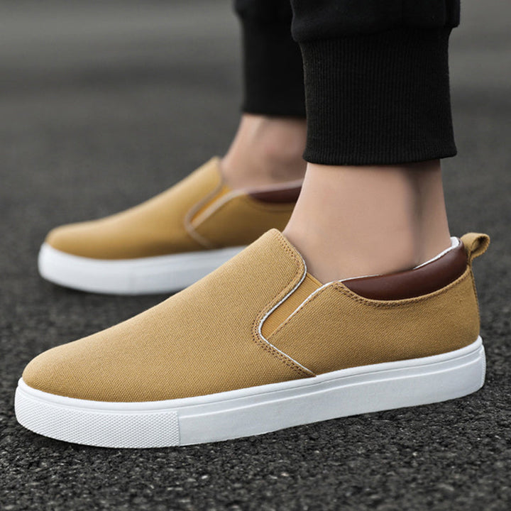 Herren trägt Lennard Slip-On Canvas-Schuhe. Moderner Freizeit-Look für Frühling & Sommer.