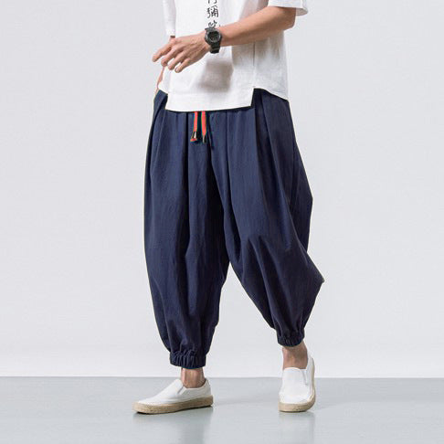 Mann trägt bequeme Haremshose in Grau für Streetwear, entspannter Schnitt perfekt für urbane Mode.