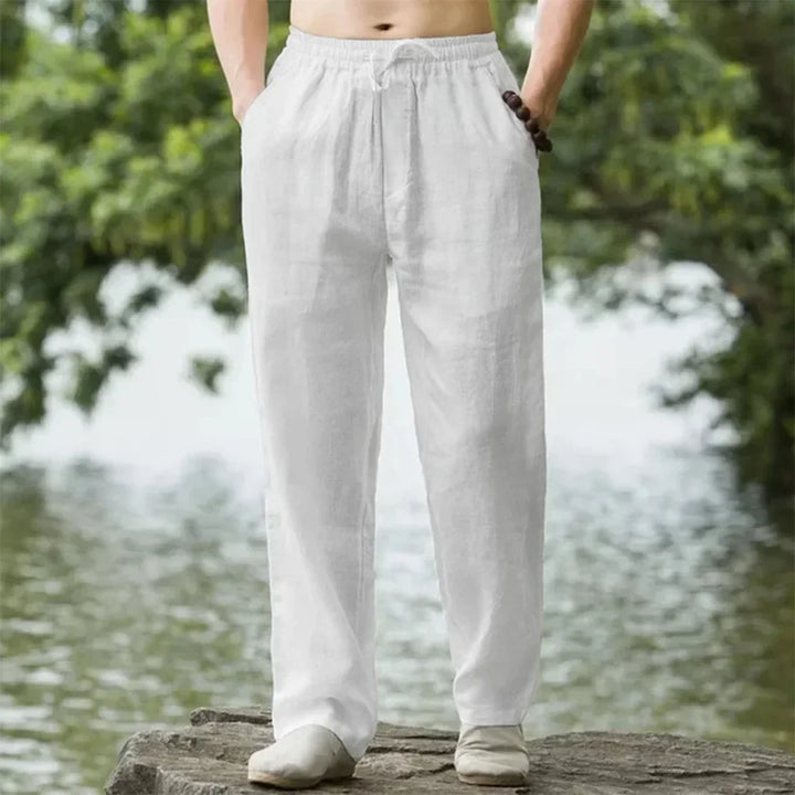 Mann trägt beige Sommerhose mit weitem Bein, Elastikbund. Lässiger, bequemer Look für Freizeit & Strand.