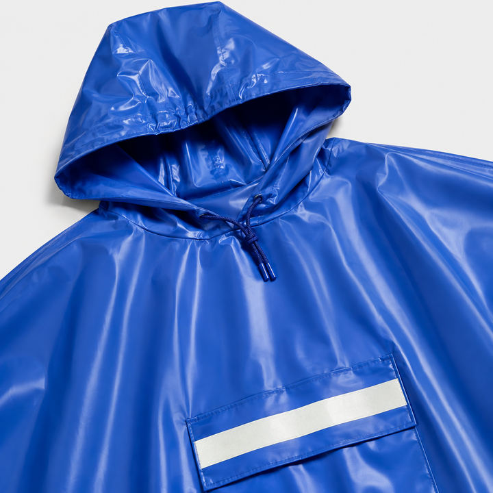 Mann trägt weiten Herren Regenponcho beim Wandern im Grünen, geschützt vor Regen, ideal für Outdoor.