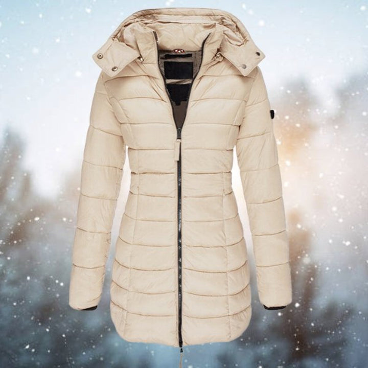 Eine stilvolle Dame trägt die lange, warme Steppjacke mit Kapuze im urbanen Winter-Setting.
