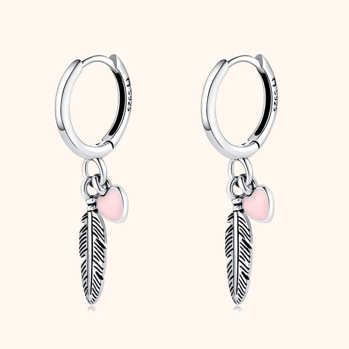 Elegante Damen Creolen mit zarter Feder und Herz Anhänger aus Silber oder Gold. Perfekter Damenschmuck.