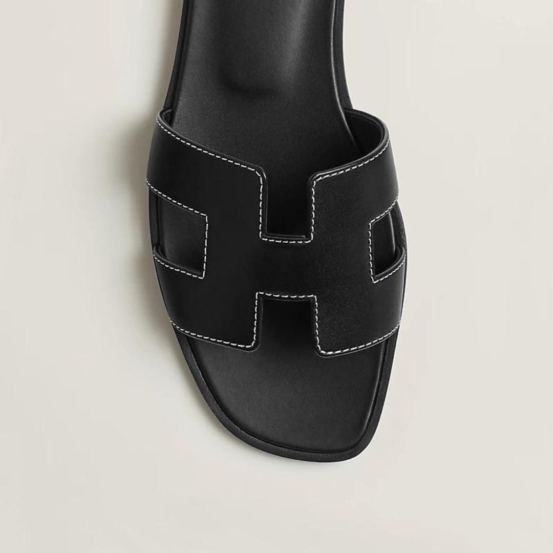 Damen Flachsandalen mit Cut-Out-Design in Schwarz, perfekt für sommerliche Eleganz und Komfort.
