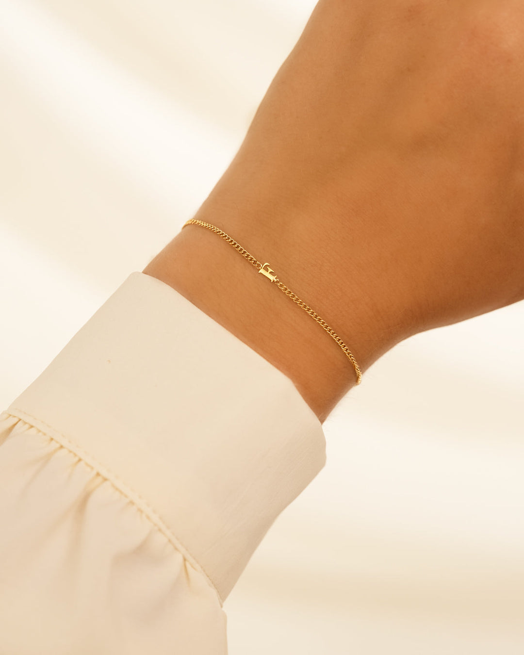 Goldenes Buchstabenarmband für Damen, personalisierbar. Elegantes Schmuckstück aus Edelstahl.