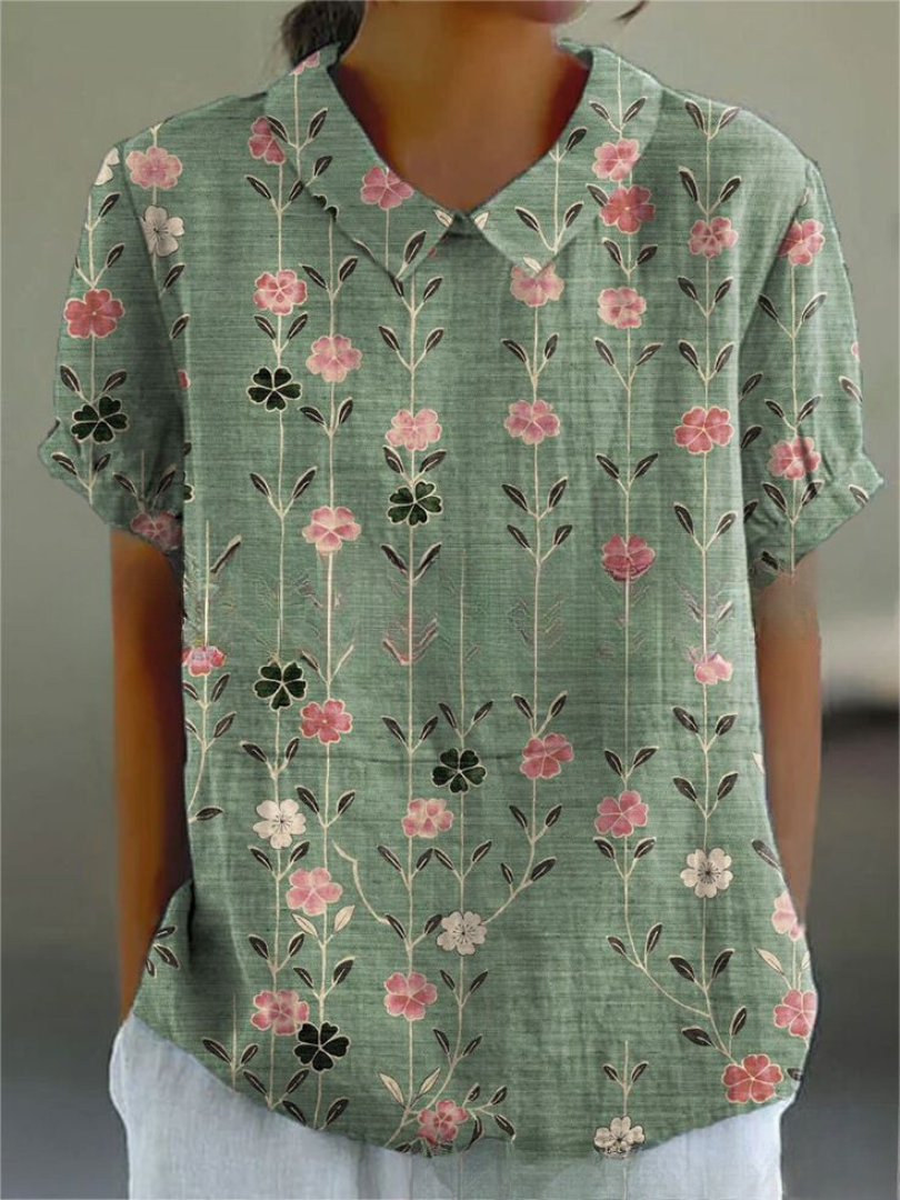 Feminine Damenbluse mit floralem Muster in Weiß-Orange, locker fallend, ideal für einen leichten Sommer-Freizeitlook.