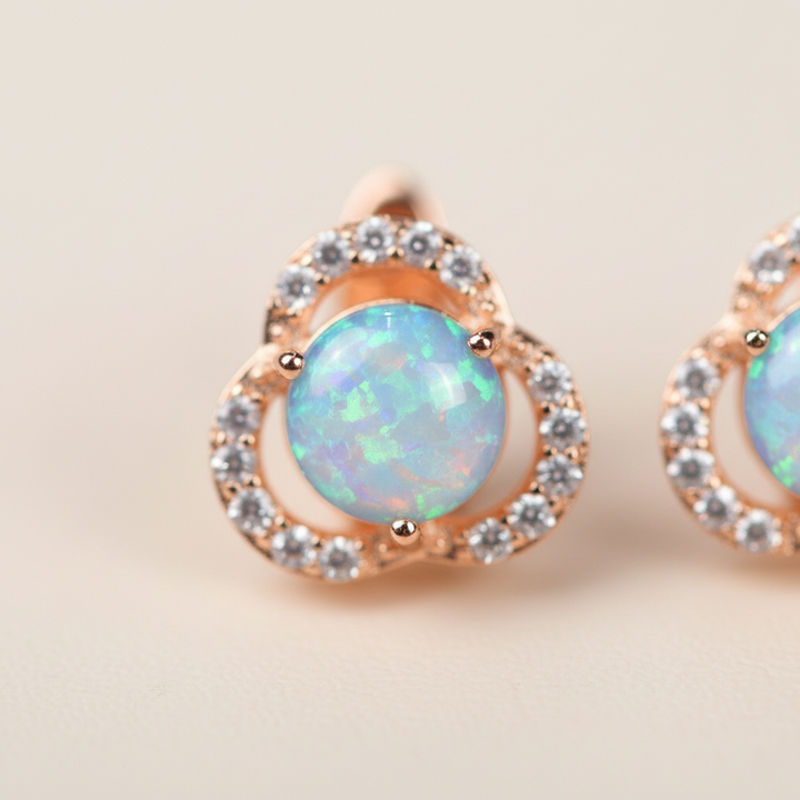 Nahaufnahme: Luxuriöse Opal-Ohrringe in Kleeblattform, Roségold-Finish, ideal als Geschenkidee.